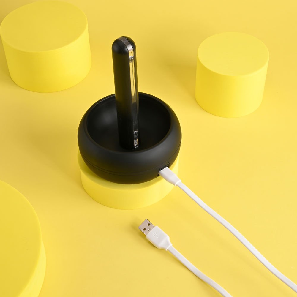 Top view of the Playboy Pleasure End Game vibrating stroker highlighting the charger base on a yellow white background | Flirty Bay adult store Perth